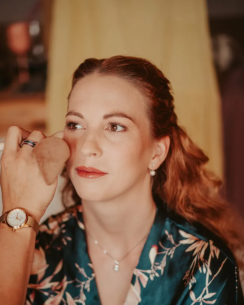 Vizážistka nanáší make-up houbičkou na modelce