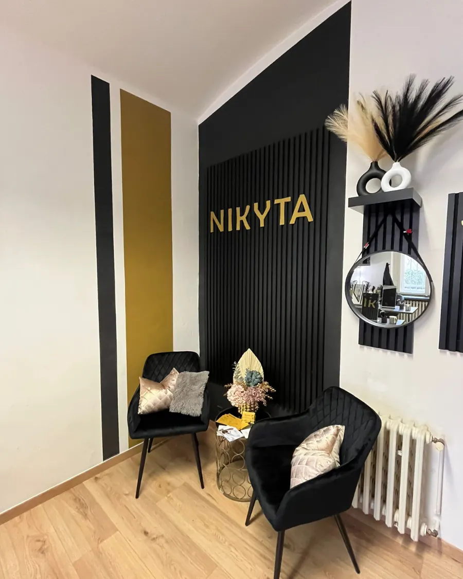 Studio NIKYTA v Praze 5 se zlatým nápisem na černé stěně